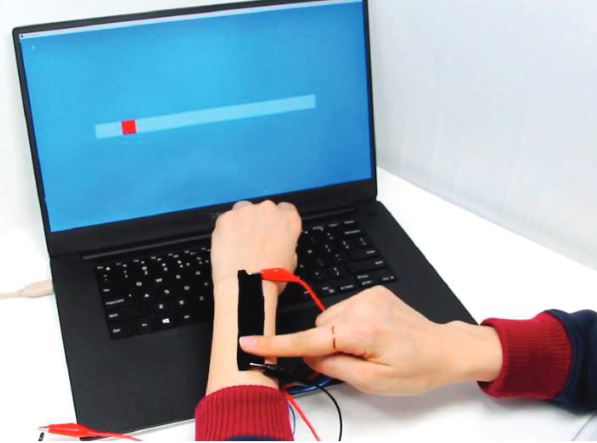 The tape sticked on the left hand and the right hand operating the tape sensor. The screen on the laptop shows the according slider.